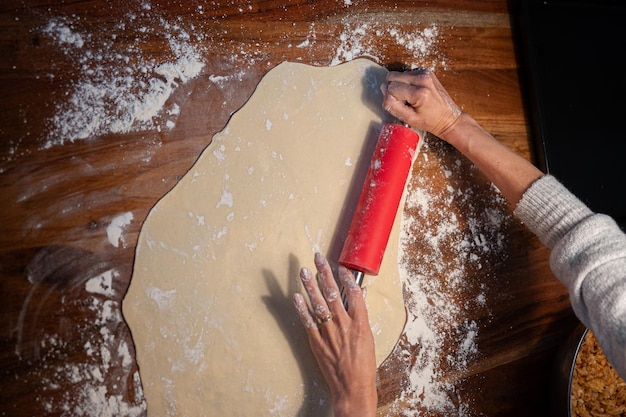 Overhead view of female hands rolling homemade pastry dough