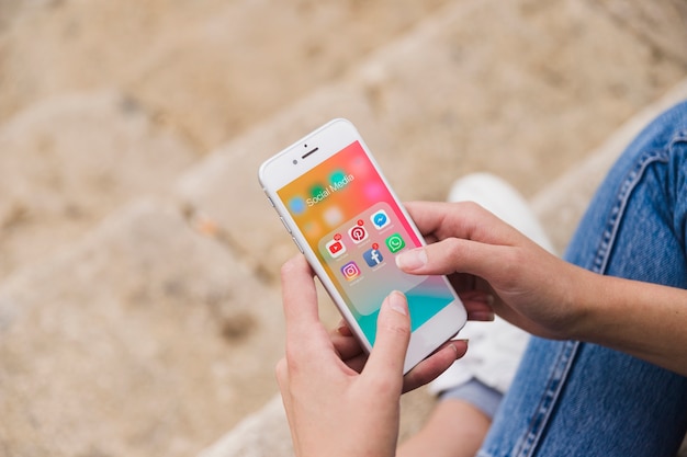 Overhead view of female's hand using social media app on cellphone