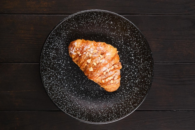 Overhead view of freshly baked croissant with caramel on a plate