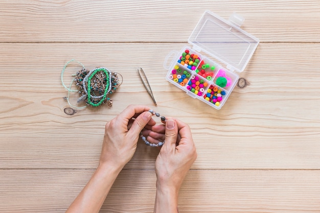 An overhead view of hand making handmade jewelry over the desk