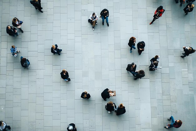 Overhead View of People Walking on a Tiled Floor