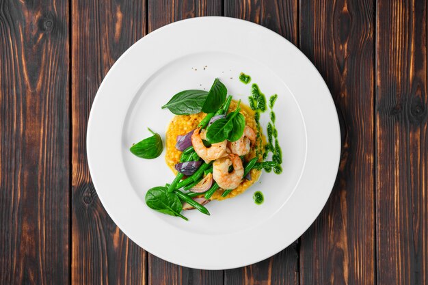 Overhead view of salad with shrimp, green bean, roasted onion and green buckwheat