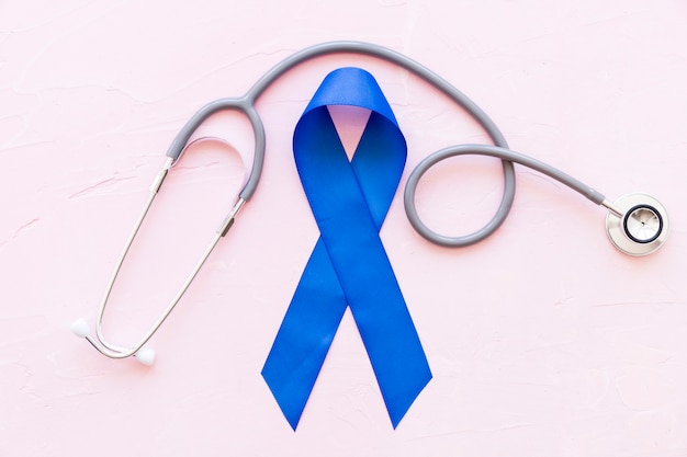 Overhead view of stethoscope over the big blue awareness ribbon