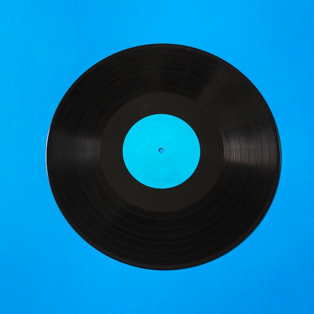 Overhead view of vinyl record on blue background