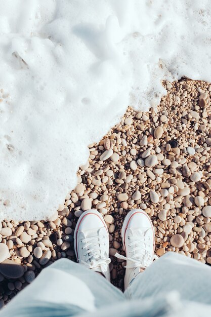 overhead view white sneakers on the beach