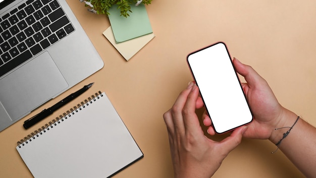 Overhead view young man holding smart phone with empty display