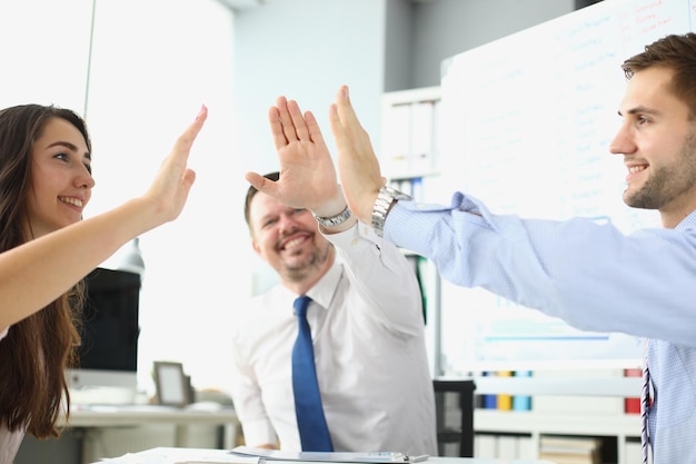 Overjoyed team of employees gives five celebrating success