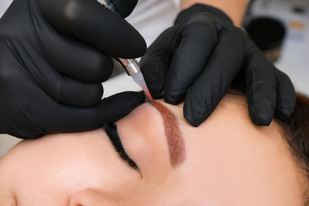 Overlapping of unsuccessful permanent makeup on the eyebrows Applying a warm tone to a cool blue color