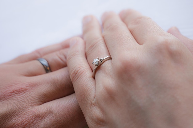 Overlapping wedding rings and couple's hands