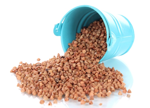 Overturned bucket with grains on white