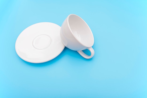 Overturned or  knocked over empty white coffee cup, mug with bowl