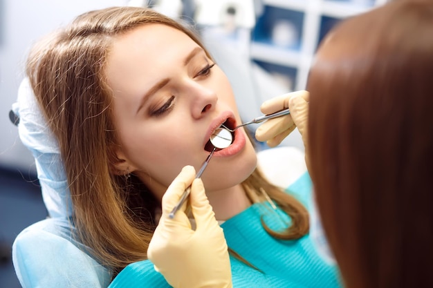 Overview of dental caries prevention Woman at the dentist's chair during a dental procedure .