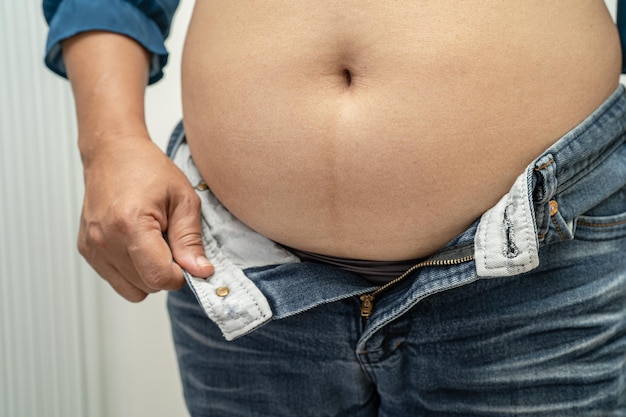 Overweight Asian woman show fat belly at office