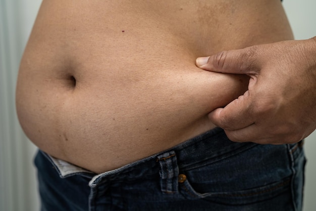 Overweight Asian woman show fat belly at office