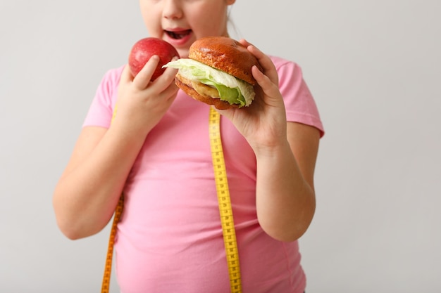 Overweight girl with healthy and unhealthy food