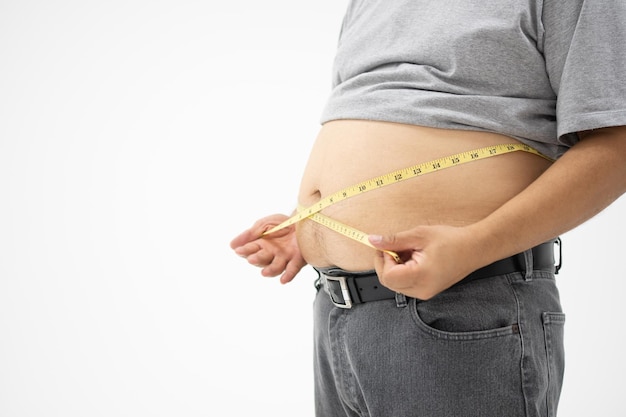 Overweight Man uses a measurement tape for measures his fat belly isolated on white background Concept of Healthcare medicine and Weight loss