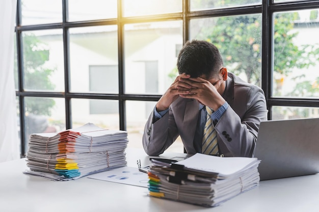 Overworked sad businessman with stack of papers business people deadline stress and paperwork concept