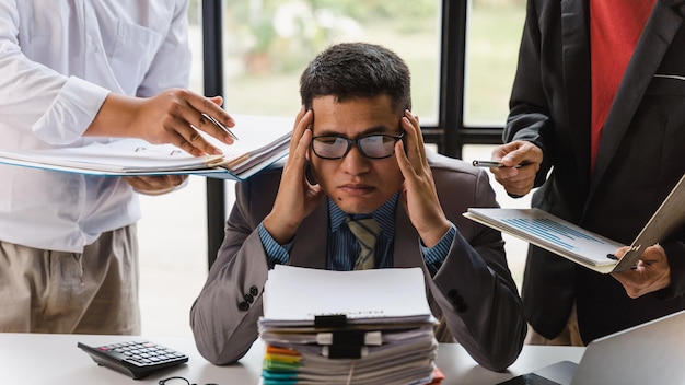 Overworked sad businessman with stack of papers business people deadline stress and paperwork concept