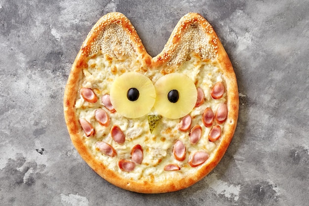 Owlshaped pizza for kids with cream cheese sauce chicken Vienna sausage pineapple olives pickled cucumber and sesame