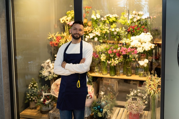 The owner of a bouquet boutique next to a refrigerator with fresh flowers