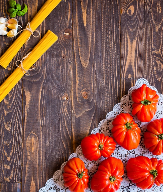 Ox heart tomatoes on rustic wood background free space for text.