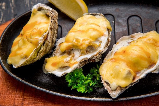 Oysters in a pan in a creamy sauce and cheese