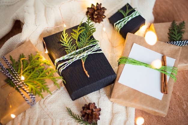 pack christmas gift boxes with twigs and ribbon