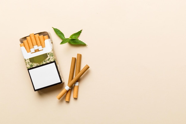 Pack of menthol cigarettes and fresh mint on colored table Menthol cigarettes top view flat lay