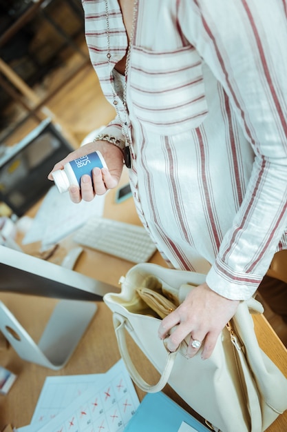 Photo pack of vitamins. close up of pregnant stylish young woman holding little pack of vitamins