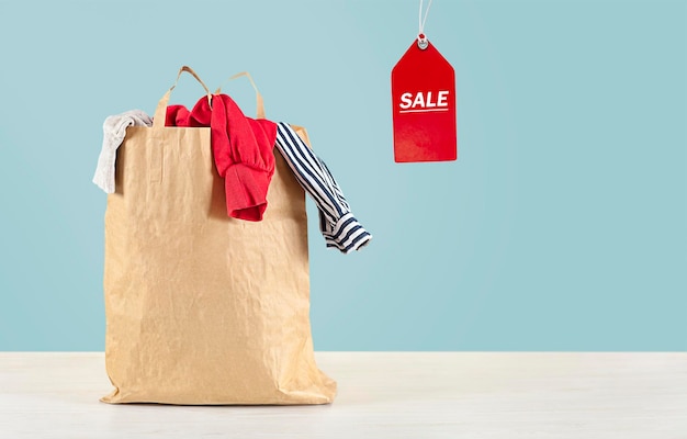 package with clothes on the table on a blue background. Sale concept