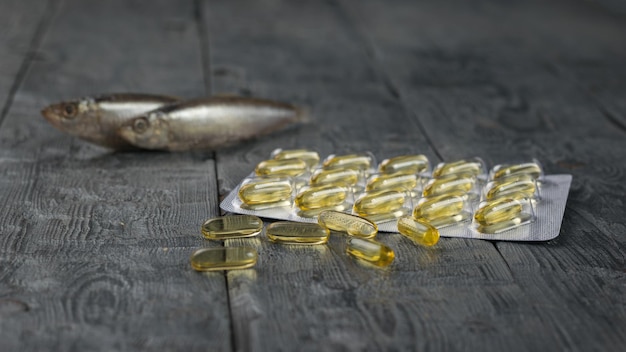 A package with fish oil capsules on a fish background on a wooden table