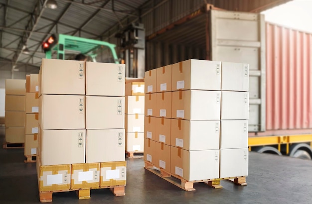 Packaging Boxes Stacked on Pallets Loading with Shipping Cargo Container Freight Trucks Logistics