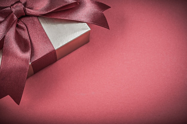 Packed present box on red background holidays concept