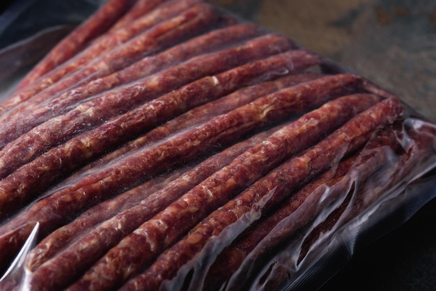 Packing Smoked Sausages closeup in Vacuum Bag Readymade Meat Products for Supermarket