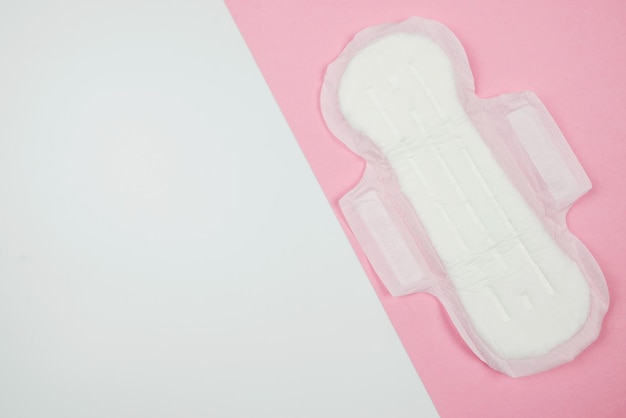 Pad sanitary napkin on a pink and white background Menstruation feminine hygiene top view copy space