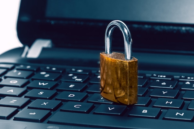 Padlock on computer laptop keyboard. Concept of Internet security, data privacy, cybercrime prevention. Selective focus.