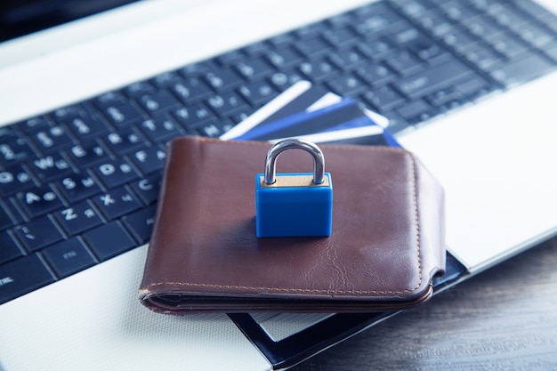 Padlock, wallet and credit cards on the computer keyboard. Credit card security