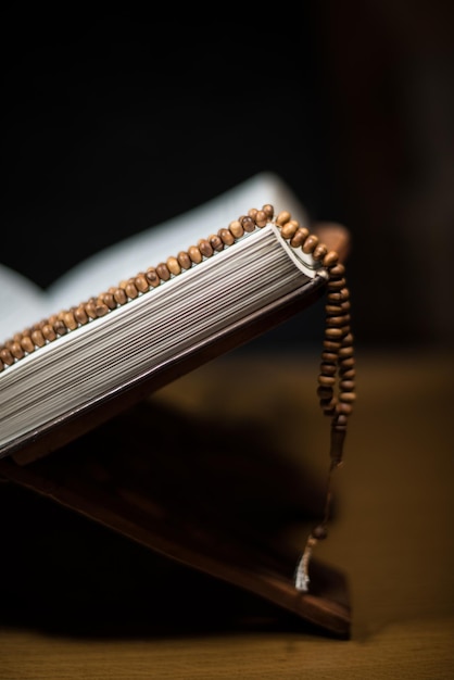 pages of holy koran and rosary at the book