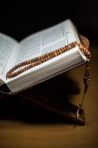 pages of holy koran and rosary at the book