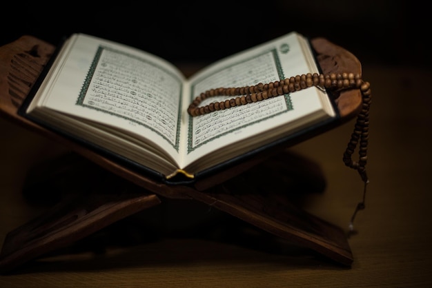 pages of holy koran and rosary at the book