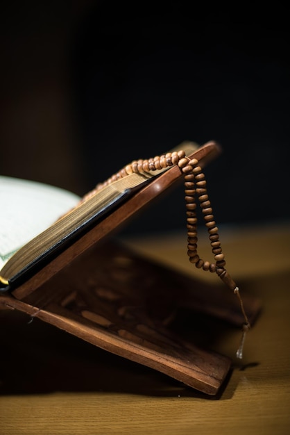 pages of holy koran and rosary at the book