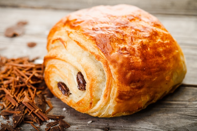 Pain au chocolat with chocolate lying on old wooden table