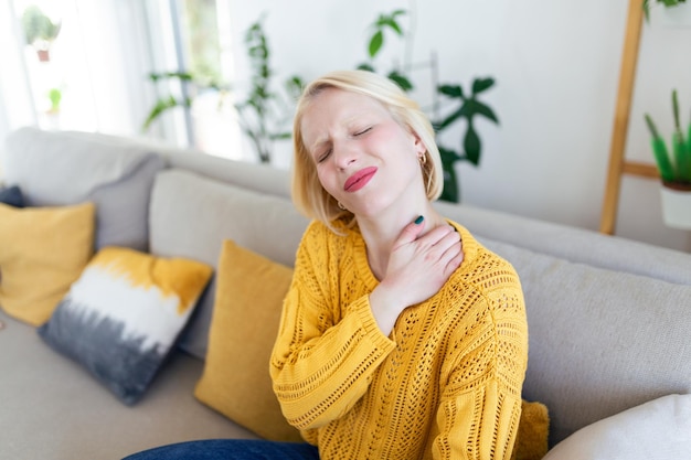 Pain in the shoulder Upper arm pain People with bodymuscles problem Healthcare And Medicine concept Attractive woman sitting on the bed and holding painful shoulder with another hand