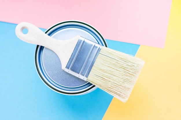 Paint brush with natural bristles for paint and metal can on colorful background