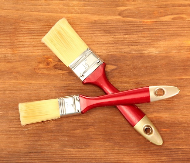 Paint brushes on wooden background