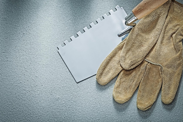 Paint scraper leather protective gloves on concrete background construction concept