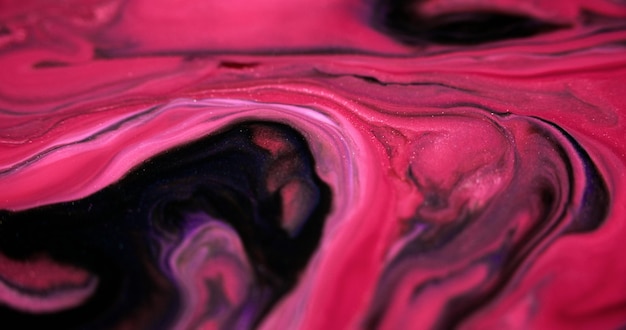 Paint swirl shiny fluid mix defocused pink black color shimmering glitter particles acrylic ink