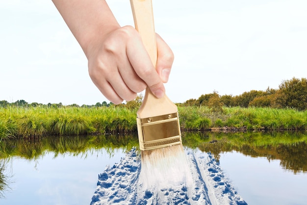 Paintbrush paints snow way in swamp in summer