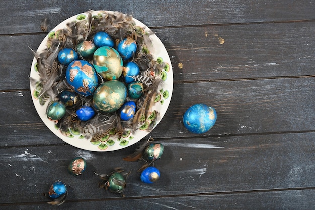 Painted colored Easter eggs on animal skin in plate on dark wooden background Boho stile