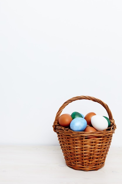 Painted Easter eggs in a basket on a Light background Copy Space church holiday